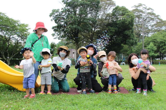 公園でシャボン玉を手にする子ども達と母親たち