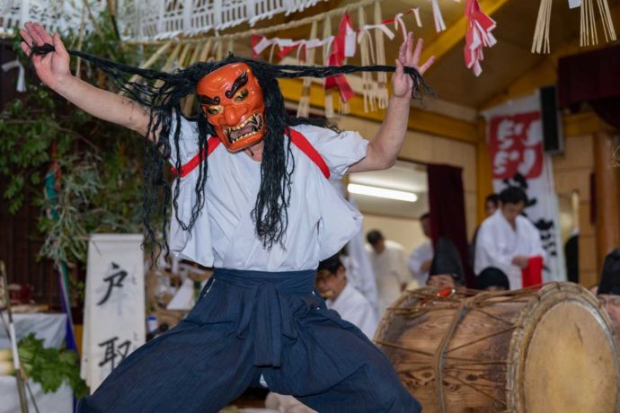 面をつけて神楽を舞う人