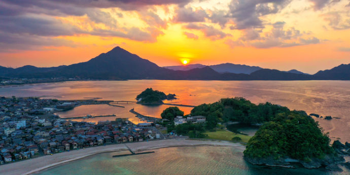 海の向こうの山に沈む夕日