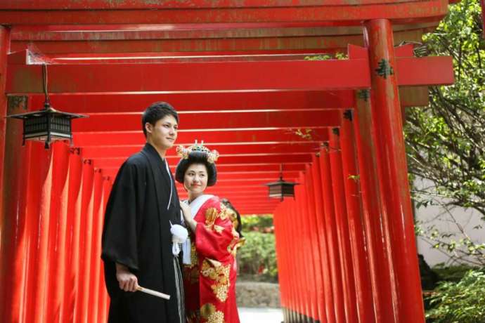 讃岐國一宮田村神社の朱色の連鳥居の前で寄り添う新郎新婦