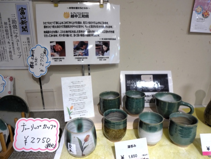 「道の駅 砺波」の併設ショップ「となみ野の郷（特産館・直売所）」で販売される「越中三助焼窯元」のコーヒーカップや湯呑など