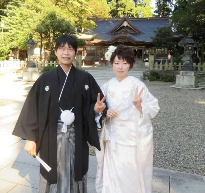 拝殿の前で写真撮影する新郎新婦