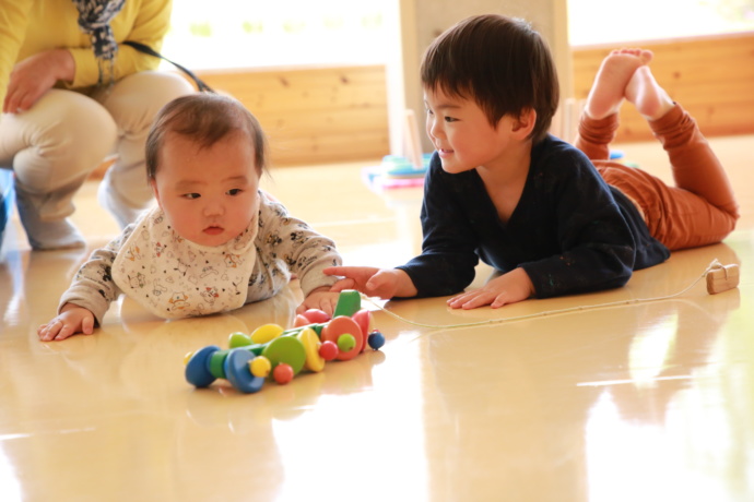 新潟県魚沼市にある「かたっくり」でおもちゃ遊びをしている赤ちゃんと男の子