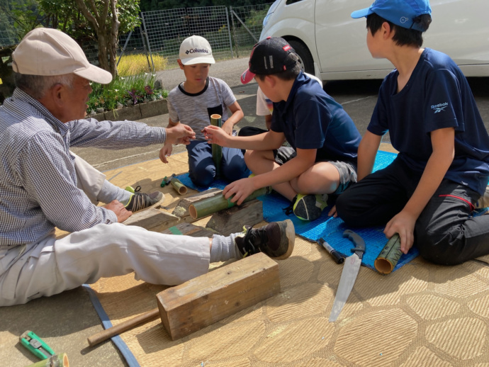 子ども達と地域の方が木工作業をしている