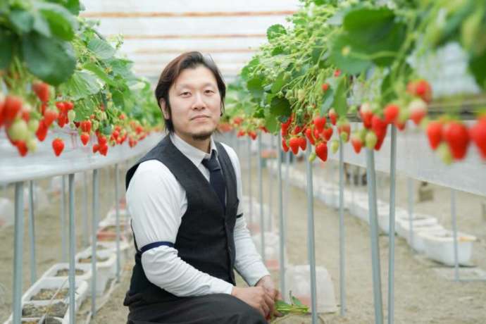 ハウス内で撮影したベジタブルガーデン代表の野村さんの写真