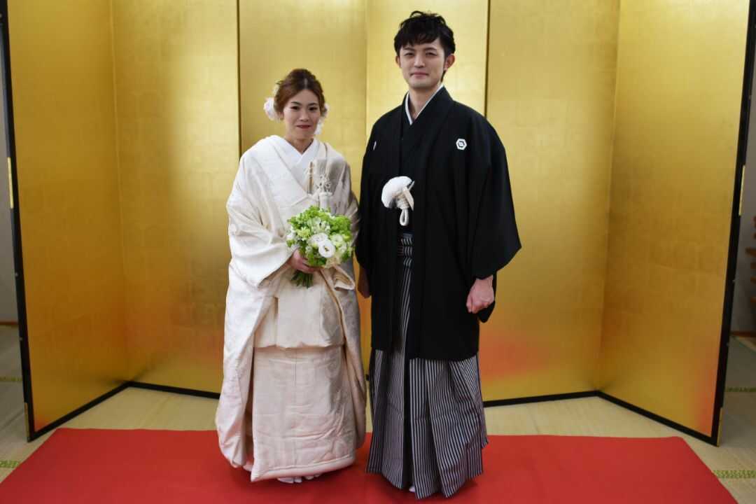 若草稲荷神社にて金屏風の前に立つ新郎新婦