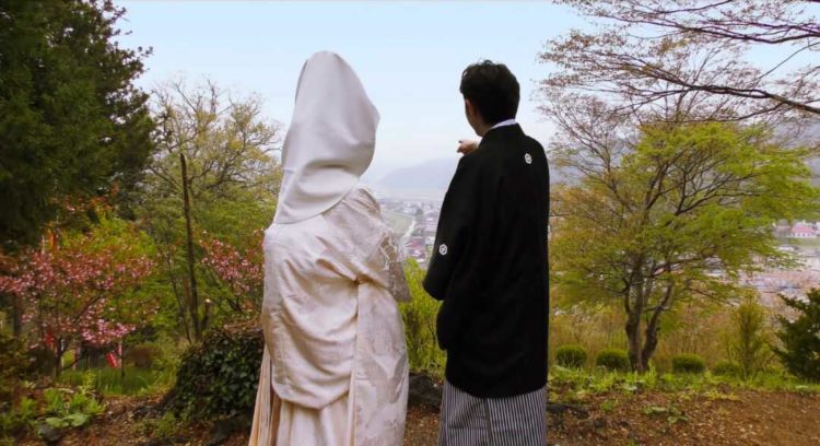 宮城県登米市にある若草稲荷神社から米川の街を眺める新郎新婦