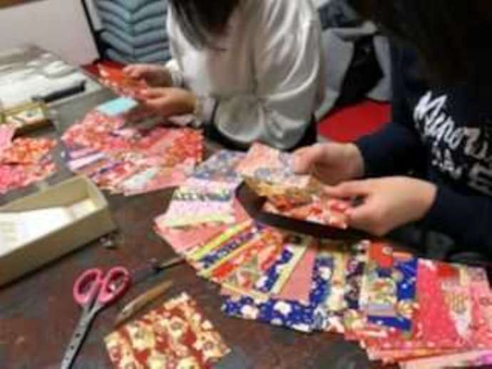 「京町屋 体験工房 和楽」で制作する和紙ピアス（イヤリング）の和紙を選んでいるところ