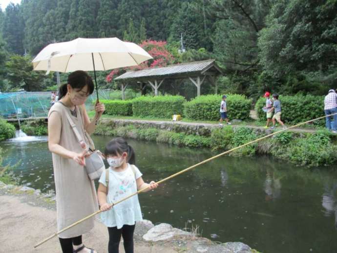 「芦谷峡 やまめの里」の貸出竿で釣りを楽しむ親子