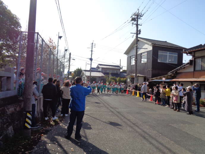 持久走大会をする小学生と、応援する地域の大人