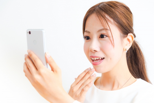 スマホを見て驚く女性