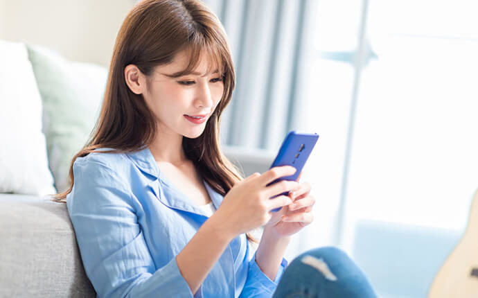 女性がスマートフォンを触っているイメージ