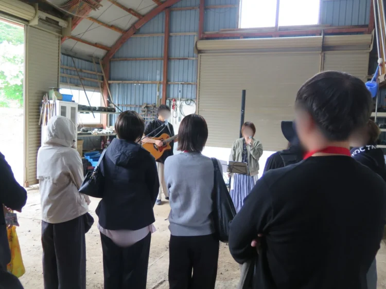 音楽活動を行う農家の倉庫で音楽ステージを楽しむ参加者