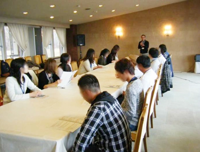 婚活イベントで男女向き合って司会者の話を聞く様子