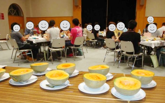 夕食に出されるメロンと食事を楽しむ参加者たち