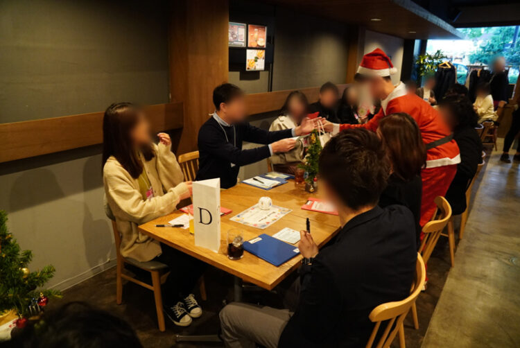 大垣市の婚活イベントでサンタクロースに扮した実行委員からプレゼントが贈られる様子