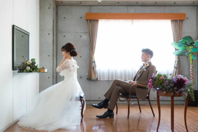 「ぶどうの森ウェディング」の支度部屋で挙式の準備をする新婦と座って見守る新郎