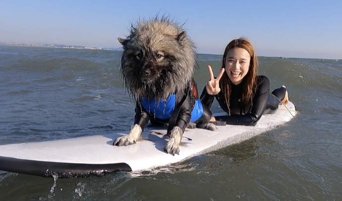 神奈川県茅ヶ崎市の「Hosoii Surf&Sports」でサーフィンをしている女性の記念撮影の様子