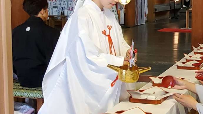 飛驒一宮水無神社の神前式で巫女がお神酒を注ぐ様子