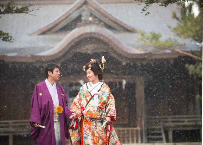 降雪の中で撮る神社境内での結婚写真