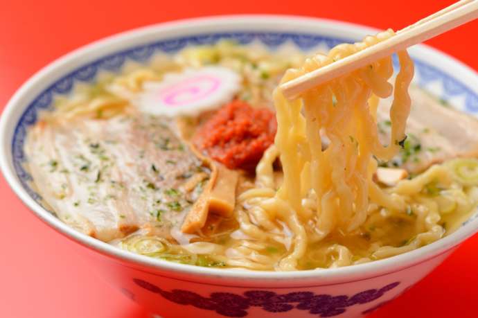 美味しそうなラーメンを箸で掬い上げる様子